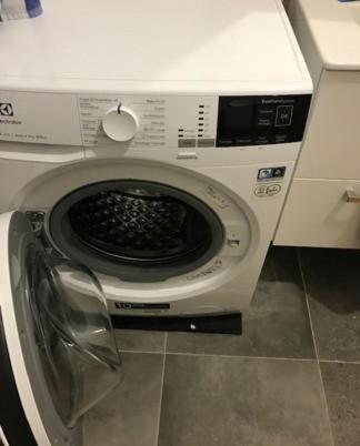 une machine à laver avec sa porte ouverte dans une cuisine dans l'établissement Location Vacances en Coeur de ville - Vue sur Mer - Tout confort, à Calvi