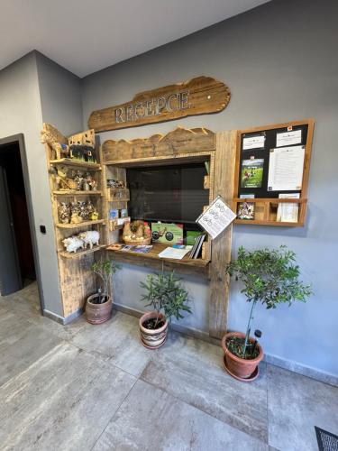a restaurant with potted plants in front of a counter at Penzion Farma Žleby in České Žleby