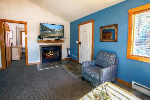 a living room with a chair and a fireplace at Timber Creek Chalets- 8 chalet in Estes Park
