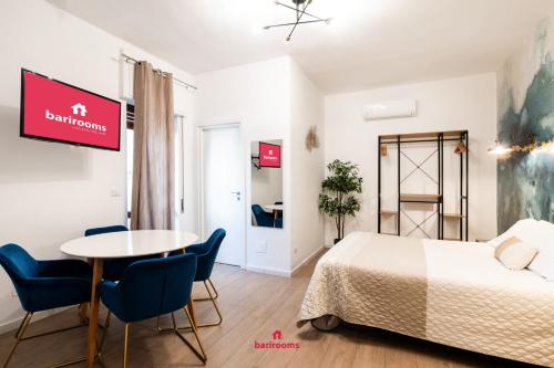 una camera da letto con un letto, un tavolo e delle sedie di BARIROOMS - Melo Suites a Bari