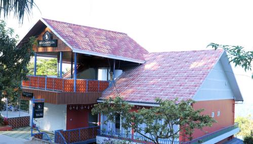 a building with a red roof and a parking meter at Bougainvillea Homestay Munnar in Munnar