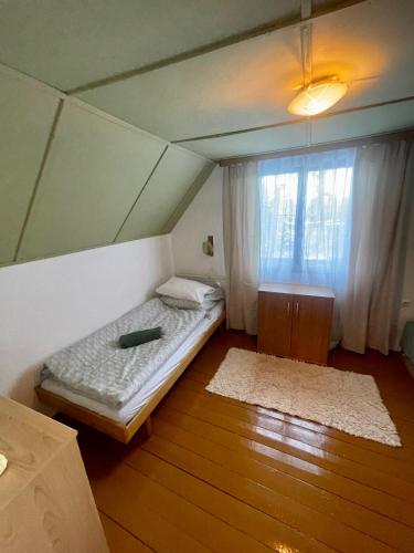 a small bedroom with a bed and a window at Chata Jelka in Tatranska Strba