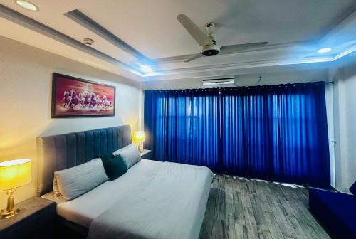 a bedroom with a bed and a window with blue lights at Executive appartment in bahria hieghts 1 in Rawalpindi