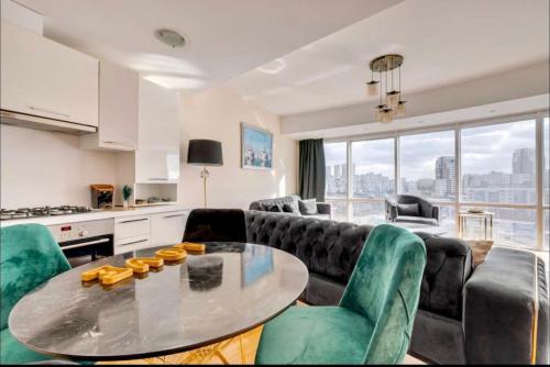 a living room with a table and some green chairs at Residence with city view in Basaksehir