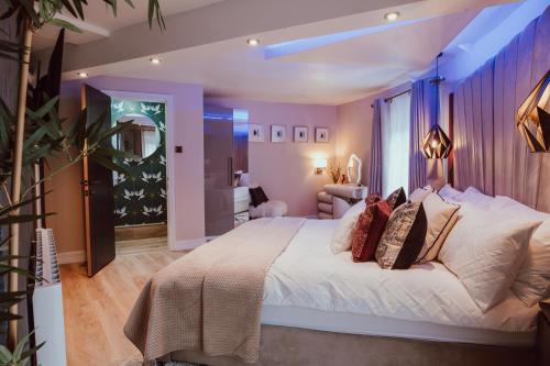 a bedroom with a large white bed with pillows at The Penthouse Luxury Central Apartment in Glossop