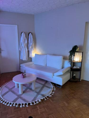 a living room with a couch and a table at Flower spa - Jacuzzi intérieur - T2 in Toulouse