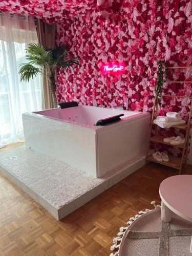 a pink salon with a pink wall with flowers at Flower spa - Jacuzzi intérieur - T2 in Toulouse