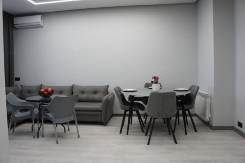 a living room with a table and chairs and a couch at G Suite in Yerevan