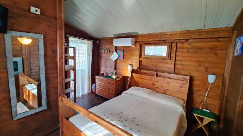 a bedroom with a bed in a wooden cabin at Dimora Acqua del Fico in Castellabate