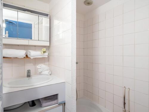 une salle de bain blanche avec un lavabo et un miroir dans l'établissement Charmant studio jardin bord de mer Carnac-Plage, à Carnac