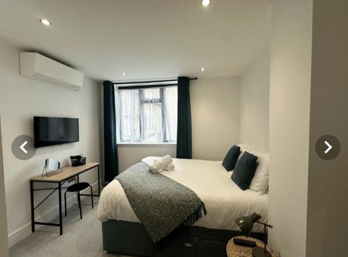 a bedroom with a bed and a desk and a window at City Centre Apartments - 1 Bed Apartments - 5 Min Walk from Train Station - Designed for Professionals - Free WiFi - Full Kitchen - Sofa Bed - Ideal for Long Work Stays in Peterborough