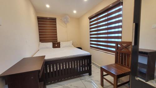 a bedroom with a bed and a desk and a window at NewCastle Holidays Resorts-Entire Property 5 Bedrooms-Great Mountain & River View-Between Munnar & Idukki with Kitchen in Idukki