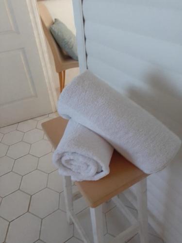 ランバーツ・ベイにあるCoCo de Mer - Self Catering Log 2のバスルームのスツールにタオルを積み重ねます。
