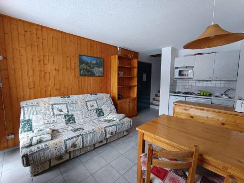 une chambre avec un lit et un mur en bois dans l'établissement Studio duplex skis aux pieds, 4 pers, animaux admis - FR-1-445-116, à Montgenèvre