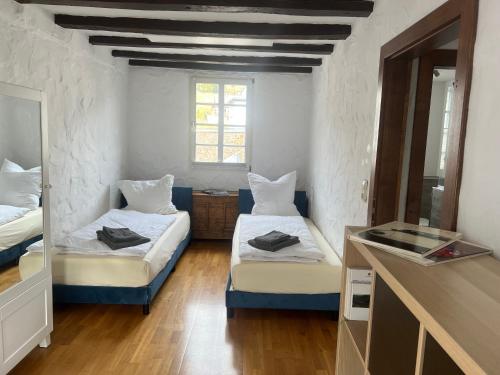 a small room with two beds and a mirror at NringRooms am Markt in Adenau