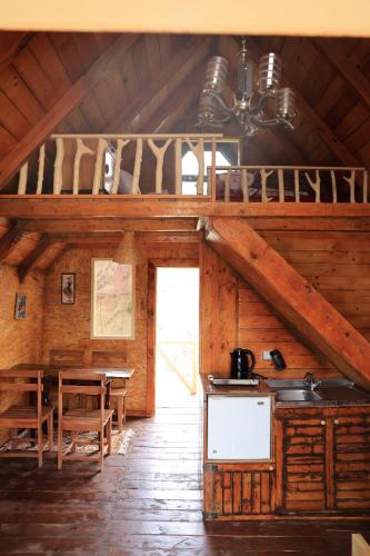 a kitchen and dining room of a log cabin at Shtepizat e Rames Agroturizem in Librazhd