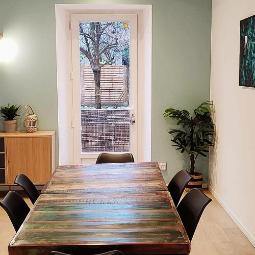 une salle à manger avec une table en bois et une fenêtre dans l'établissement Casa Luna - Une Maison à la Situation Exceptionnelle Offrant Sérénité et Confort en Plein Cœur de Bourges, à Bourges