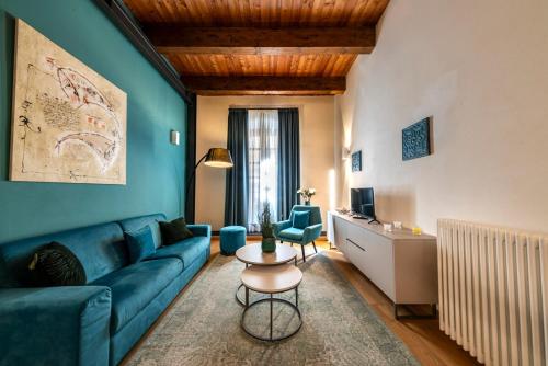 a living room with a blue couch and a table at Suite Deluxe in Palazzo Storico - Centro Sassari - Appartamento Isola Rossa in Sassari