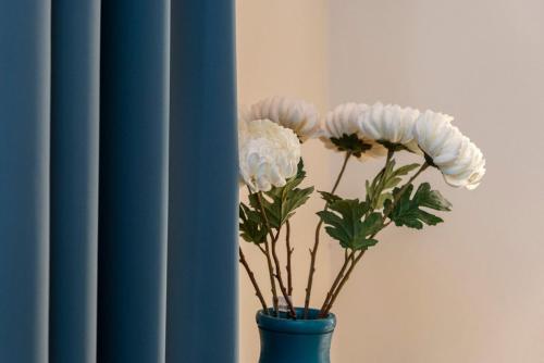 a blue vase with white flowers in it at Suite Deluxe in Palazzo Storico - Centro Sassari - Appartamento Isola Rossa in Sassari