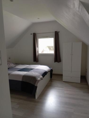 une chambre avec un lit et une fenêtre dans l'établissement La Petite Maison, à Ricarville-du-Val