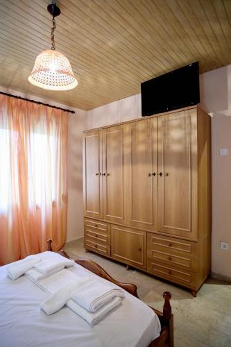a bedroom with a bed with a television on top at White lilies the house of gourmet flavours in Chios