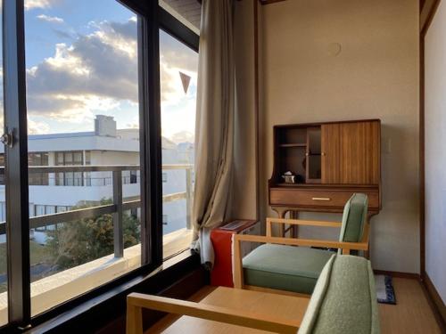 a room with a room with a desk and a window at Infinito Hotel and Spa in Shirahama