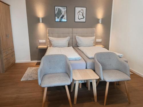 a bed in a room with two chairs and a bed at Hotel Traube Rheinhessen in Worms