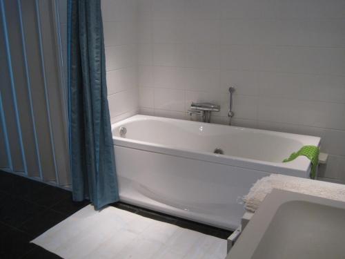 a white bath tub in a bathroom with a shower at Spacious scenic in Stockholm