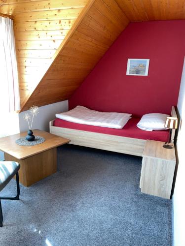a bed in a room with a red wall at Ferienwohnung im Steinachtal in Nagold