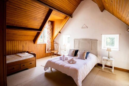 une chambre avec un grand lit dans un grenier dans l'établissement Jolie maison en pierre proche de la plage d'Omaha, à Vierville-sur-Mer
