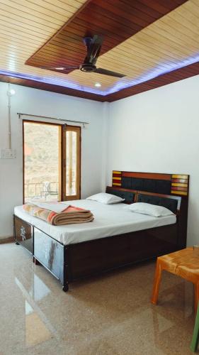 a bedroom with a large bed with a ceiling at DJSR Resort in Barkot