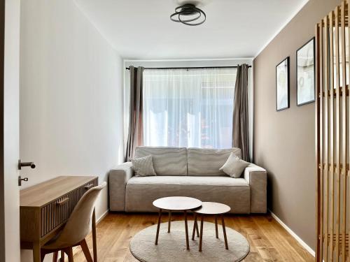 a living room with a couch and a table at YUVA HOMES Germering - 100m2 - nahe München - 2 Bäder - Garten&Terrasse - S-Bahn in Germering