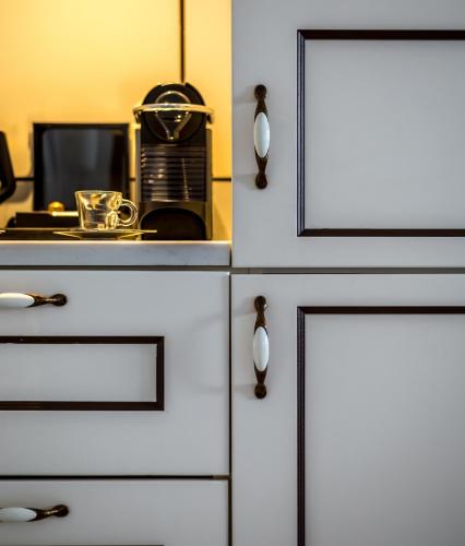 a kitchen with white cabinets and a toaster oven at Edmond Luxury Hotel & Spa in Rosh Pinna