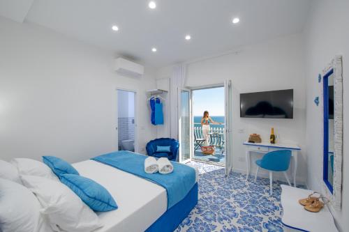 プライアーノにあるVilla Teresea- Just steps from the beachのベッドとバルコニー付きのホテルの部屋