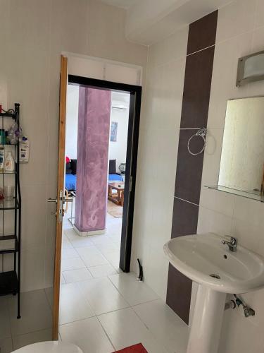 a bathroom with a sink and a door to a room at STUDIO POSEIDONIA apartment 75sqm CORINTH CANAL in Korinthos
