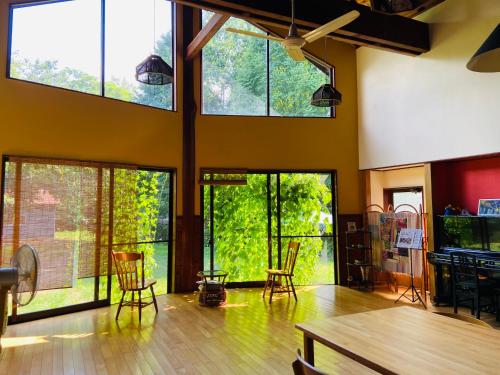 a room with large windows and a table and chairs at ロッジ星の時間 Lodge in Hokuto