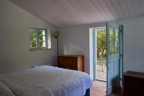 een slaapkamer met een bed en een glazen schuifdeur bij L'écrin de la Pinède in La Barre-de-Monts