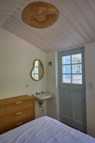 une chambre avec un lit, un lavabo et une fenêtre dans l'établissement L'écrin de la Pinède, à La Barre-de-Monts
