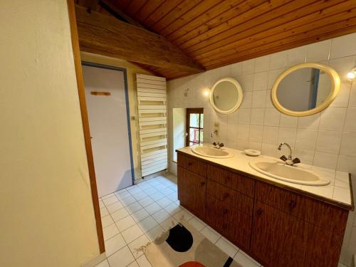 Grande Maison au Calme في La Merlatière: حمام به مغسلتين ومرآة