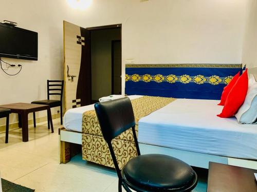 Habitación de hotel con 2 camas, mesa y silla en Shree Kesar Inn, en Udaipur