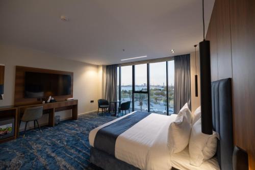 a hotel room with a bed and a large window at nasim aizraq hotel فندق نسيم ازرق in Jeddah
