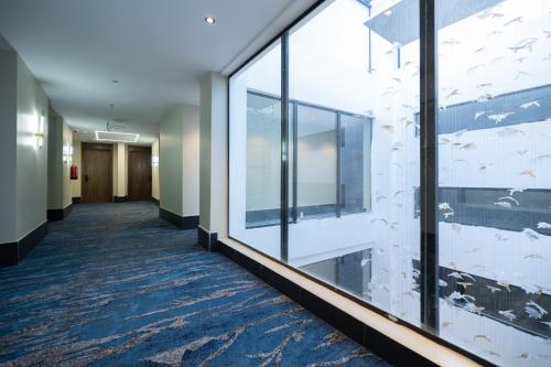 a hallway in a hospital with glass windows at nasim aizraq hotel فندق نسيم ازرق in Jeddah