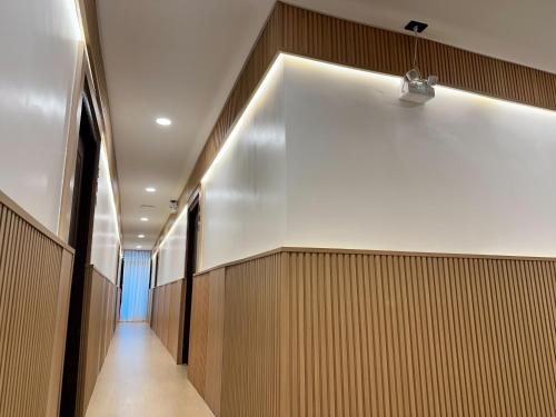 a hallway of a building with a light on the wall at Winston Hotel in Bangkok