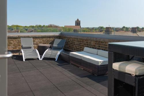 two chairs and a bench on a roof at The Loft Margate in Margate