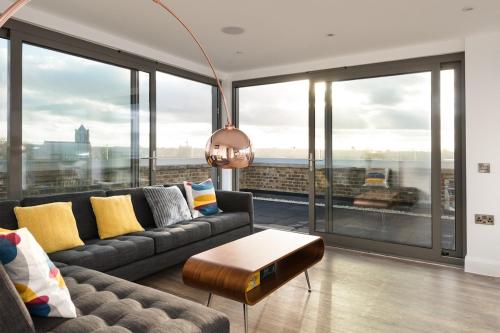 a living room with a couch and large windows at The Loft Margate in Margate