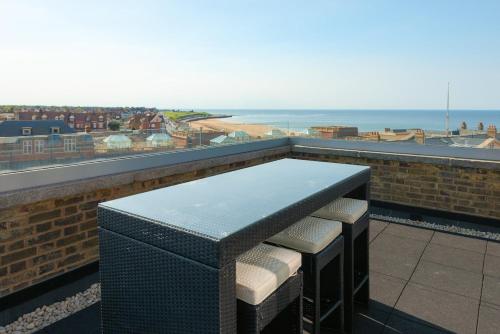 a table on a balcony with a view of the ocean at The Loft Margate in Margate