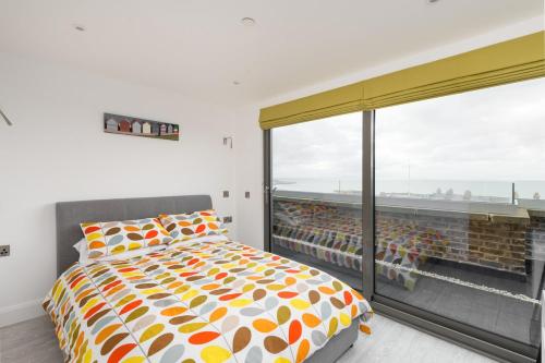 a bedroom with a bed and a large window at The Loft Margate in Margate