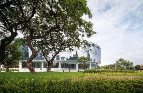 a building with a tree in front of it at Winston Hotel in Bangkok