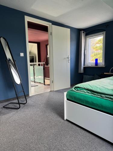 a bedroom with blue walls and a bed and a mirror at ErzgebirgsLoft in Annaberg-Buchholz