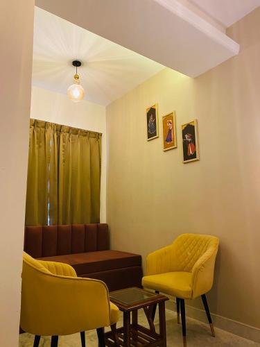 a living room with a couch and two chairs at Sitevi Inn & Suites in Kota